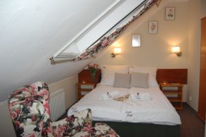 fotel w kwiaty i łóżko widok-9